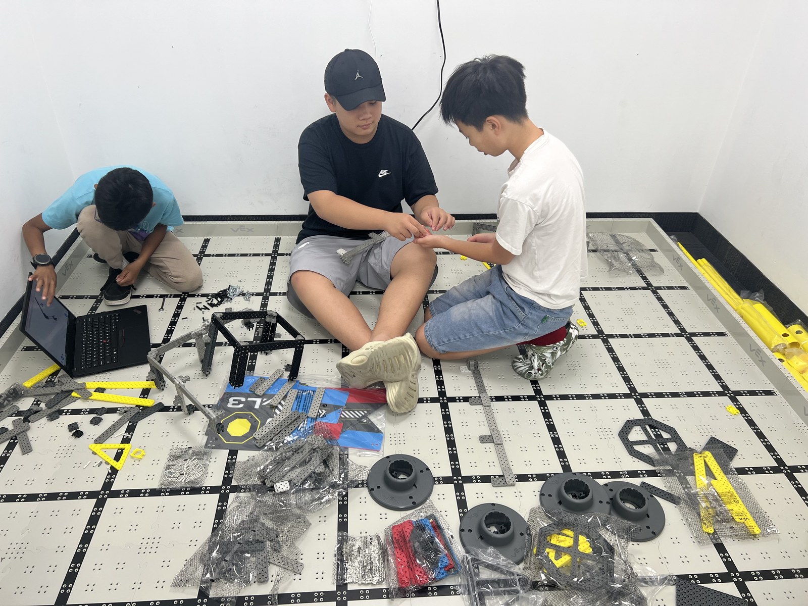 Students assembling a VEX robot on the competition field